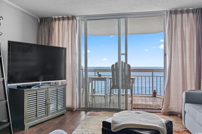 Living room with plenty of natural light, a water view, a textured ceiling, and wood finished floors | Image 26