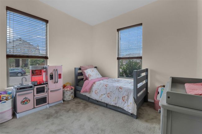 Carpeted bedroom featuring freestanding refrigerator | Image 14