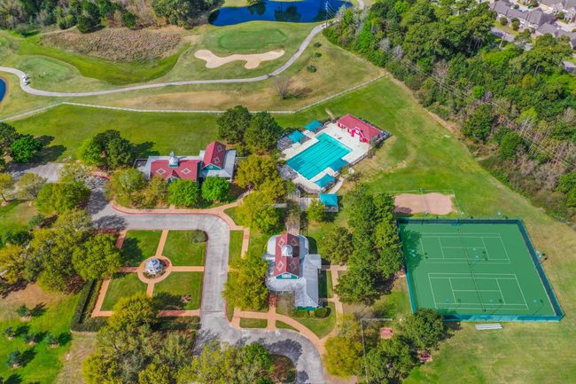This aerial view shows a picture of ONE of the two community center areas in Windrose. Here you can see our Meeting House, Club House, courtyard area, 1 of 2 of the pools in the community, &tennis courts. PLUS there is a large green space for soccer goals. | Image 45