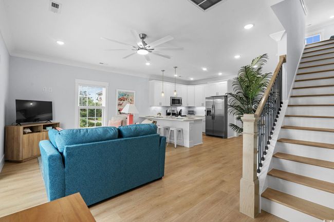 Living area with stairs, light wood-type flooring, recessed lighting, a ceiling fan, and crown molding | Image 13