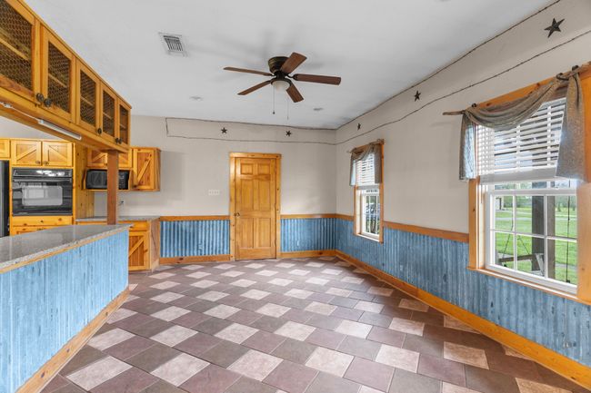 Kitchen featuring visible vents, a wainscoted wall, oven, and a wealth of natural light | Image 12