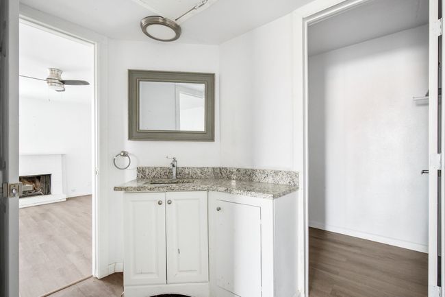Bathroom featuring ceiling fan, vanity, wood-type flooring, and a fireplace | Image 16