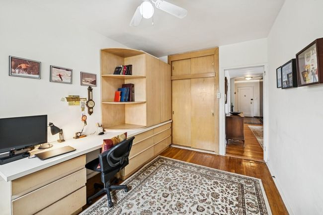 Home office with built in desk, hardwood / wood-style floors, and a ceiling fan | Image 19