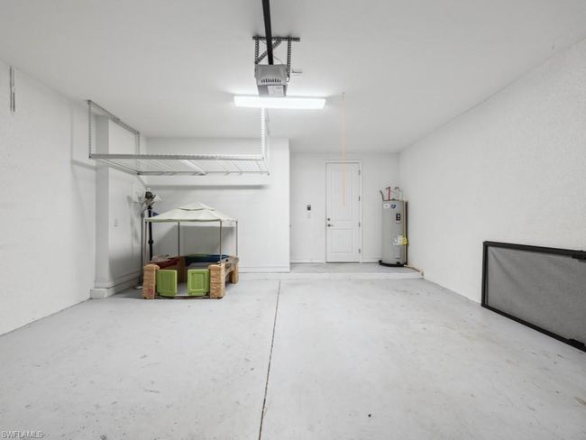 Garage with a garage door opener and water heater | Image 23