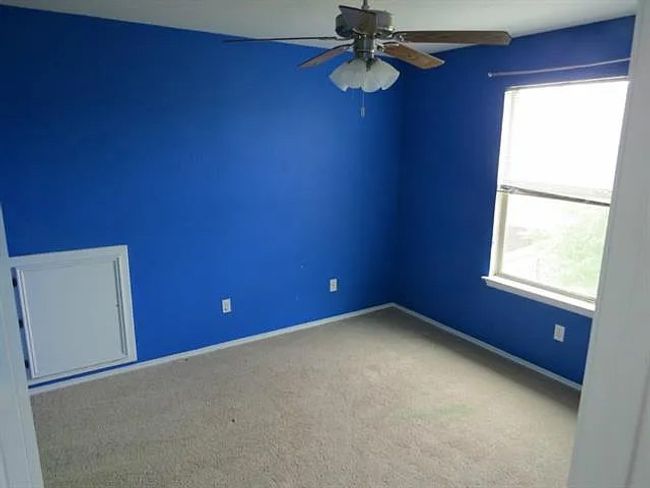 Empty room with a ceiling fan and carpet | Image 6