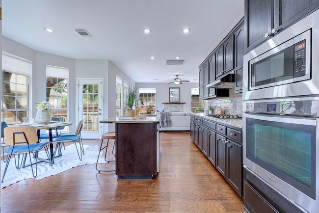 Kitchen featuring appliances with stainless steel finishes, recessed lighting, a kitchen bar, open floor plan, and ceiling fan | Image 15