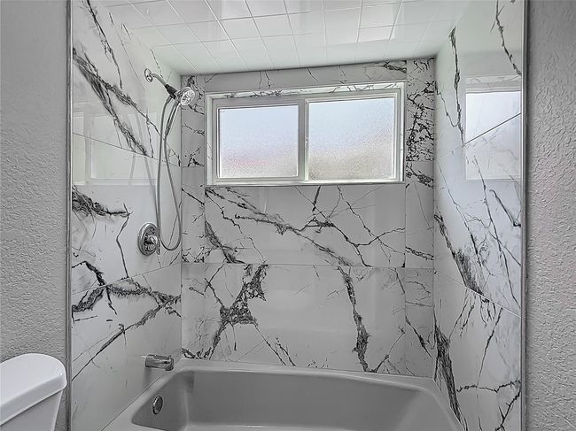 2nd bath newly tiled tub area, new vanity with quartz countertop. | Image 19