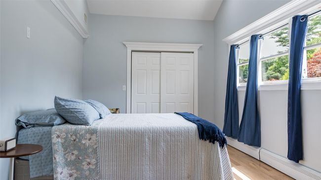 Bedroom featuring a baseboard radiator, a closet, and light wood finished floors | Image 16