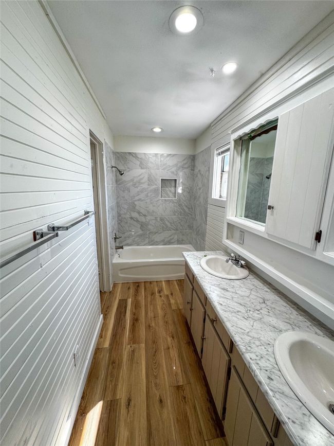 Bathroom with a sink, tub / shower combination, wood finished floors, and double vanity | Image 19