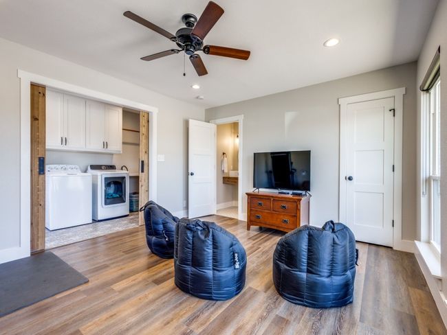 This second living area is perfect for a kids' living area or fourth "mini-primary" bedroom--double doors, ensuite bath, walk-in closets, recess lighting, fan, and beautiful views of the north acreage. Utility area is to the left past the double doors. | Image 25