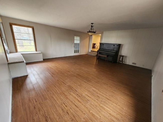 Unfurnished living room featuring wood finished floors and plenty of natural light | Image 20