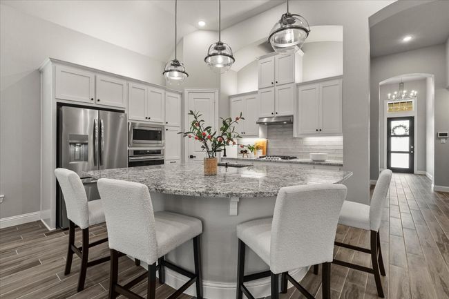 Kitchen with stainless steel appliances, dark wood-type flooring, arched walkways, tasteful backsplash, granite and recessed lighting | Image 15