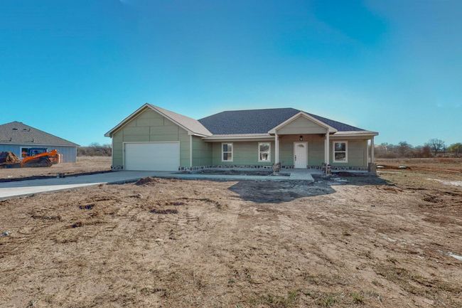 Single story home with concrete driveway, an attached garage, and covered porch | Image 4