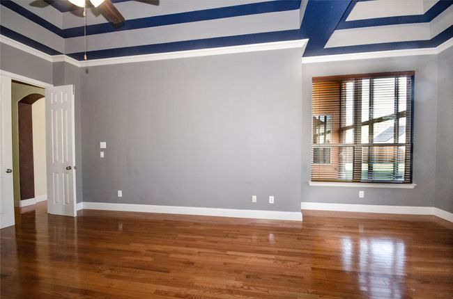 Spare room with ceiling fan, healthy amount of natural light, wood finished floors, and ornamental molding | Image 11