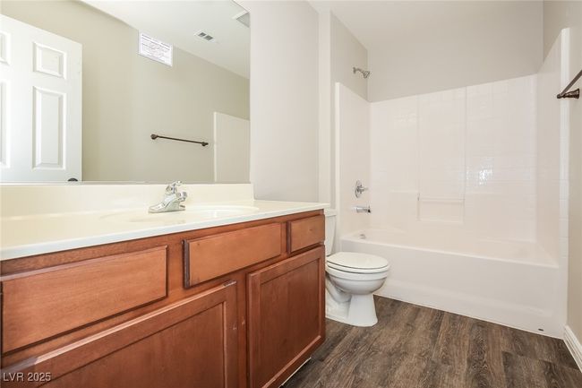 Full bath featuring visible vents, shower / bathtub combination, toilet, wood finished floors, and vanity | Image 13