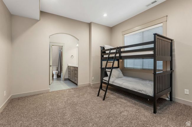 Bedroom with light colored carpet, baseboards, connected bathroom, and visible vents | Image 20