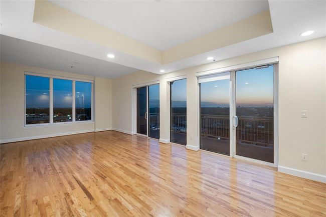 Enjoy breathtaking panoramic views in this spacious living area, featuring elegant hardwood floors and expansive windows that fill the space with natural light. Perfect for relaxation and entertaining. | Image 6