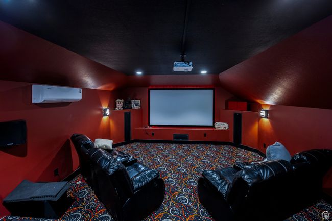 Carpeted home theater with a wall unit AC and lofted ceiling | Image 51