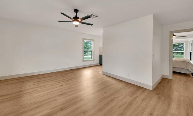 Guest house living room with ceiling fan and light wood-style flooring | Image 34