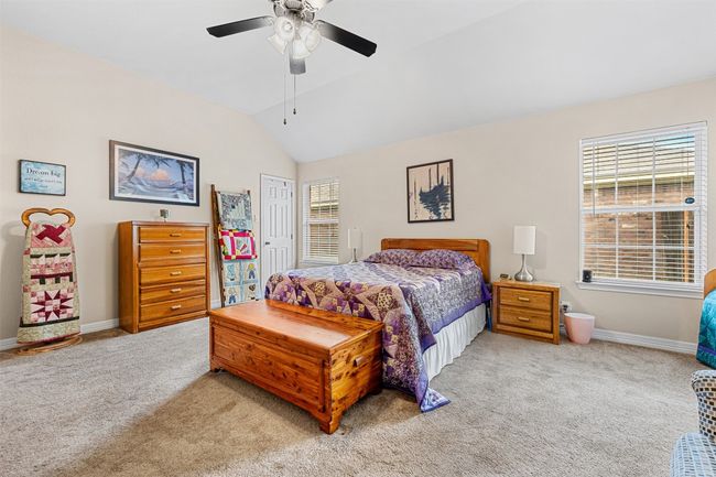 Bedroom with light colored carpet, baseboards, vaulted ceiling, ceiling fan, and a closet | Image 20