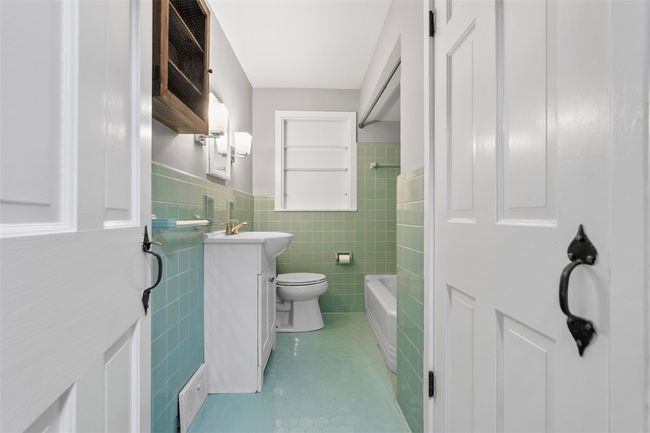 All the farmhouse charm is found in this bathroom. Beautiful ceramic tile work through out the room. Newer sink and faucet. | Image 15