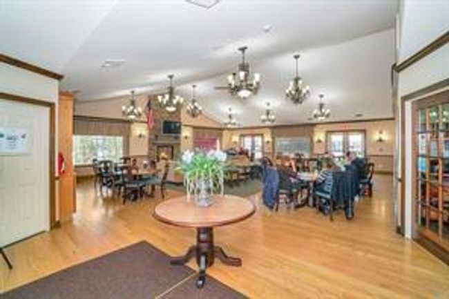 Dining area featuring wood finished floors, vaulted ceiling, and a chandelier | Image 31