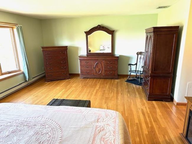 Bedroom featuring baseboard heating and light hardwood / wood-style floors | Image 13
