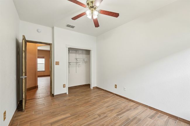 Unfurnished bedroom featuring light wood-type flooring, baseboards, arched walkways, and a closet | Image 16