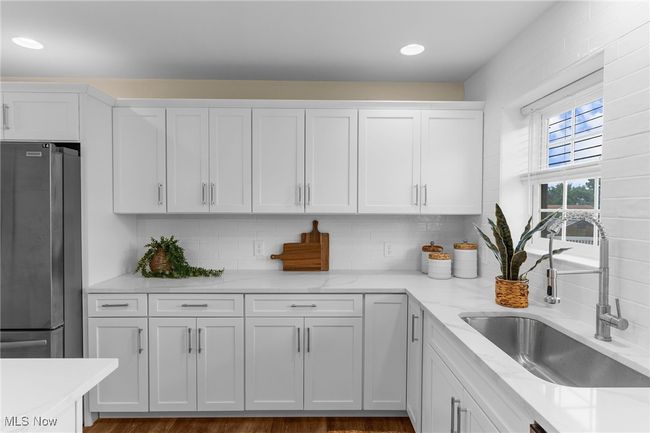 Kitchen featuring freestanding refrigerator, white cabinets, tasteful backsplash, and recessed lighting | Image 10
