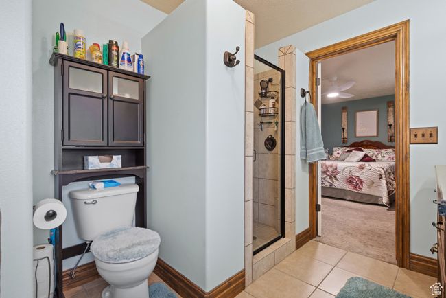 Full bathroom featuring ensuite bathroom, baseboards, toilet, a stall shower, and tile patterned flooring | Image 14