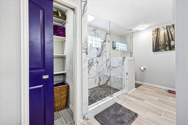 Master bath featuring convenient linen storage and stylish tile flooring for both function and style. | Image 17