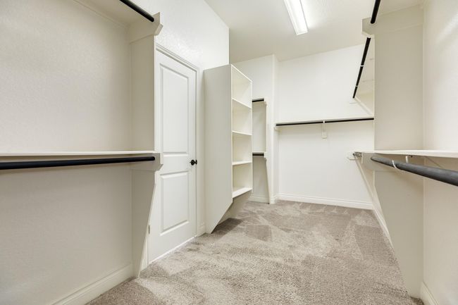 Primary has a very large walk-in closet with built-in shelves and racks. | Image 35