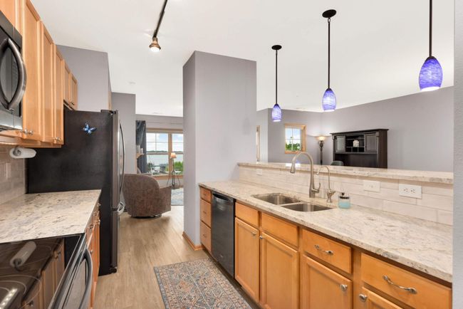 The kitchen features granite countertops, black stainless appliances and a fantastic view of Lake Minnetonka. | Image 7