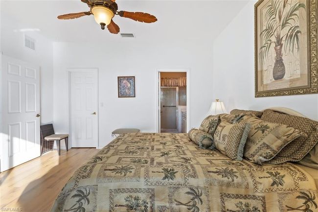 Bedroom featuring hardwood / wood-style floors, ceiling fan, and ensuite bath | Image 18