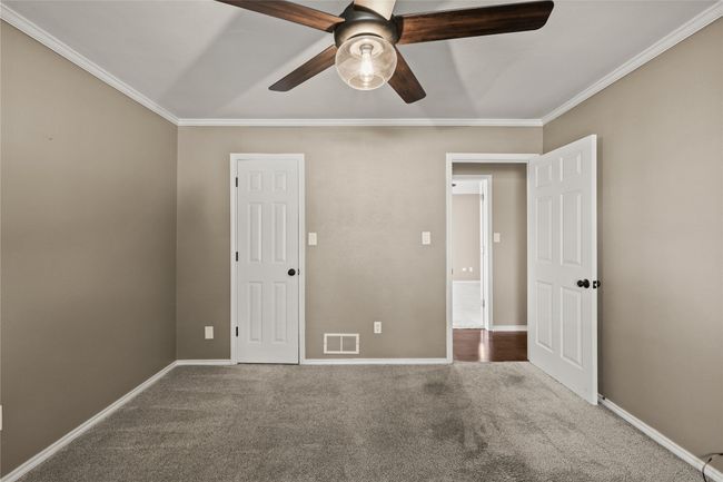 Unfurnished bedroom featuring ornamental molding, carpet floors, and a ceiling fan | Image 22