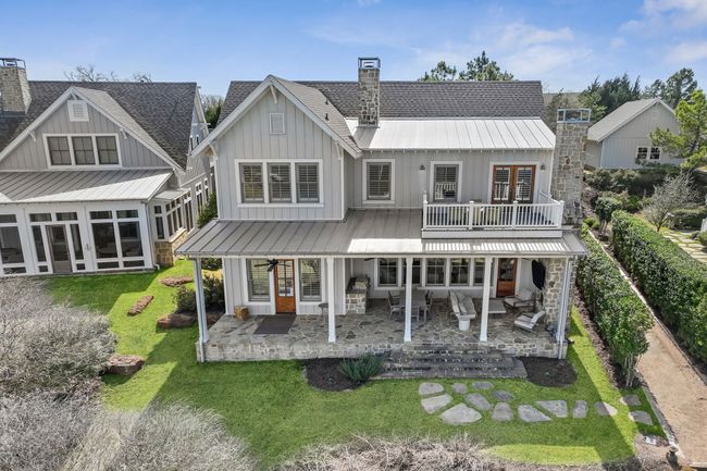Rear view of house with a chimney, board and batten siding, a yard, and a patio area | Image 37