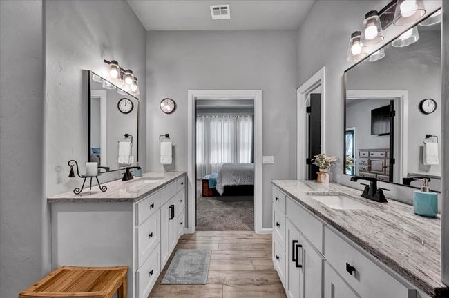 Full bath featuring two vanities, wood finished floors, and connected bathroom | Image 30