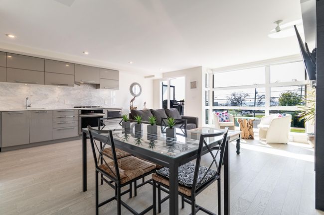 Dining area featuring light wood-style flooring, a tiled fireplace, and baseboards | Image 10