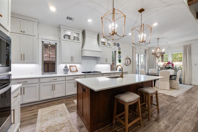 Kitchen with a sink, premium range hood, a chandelier, appliances with stainless steel finishes, and dark wood-type flooring | Image 12