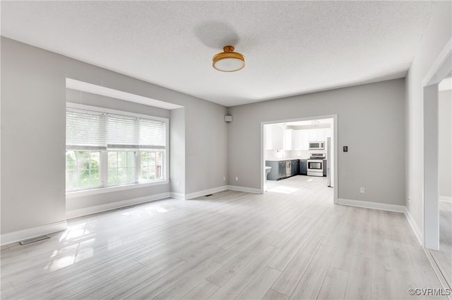 Opposite view of great room with views of the backyard from the window, as well as the kitchen | Image 10