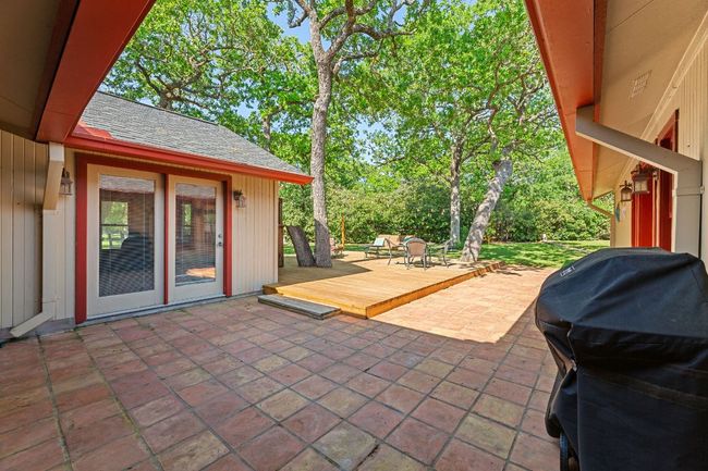 A covered patio extends to a non-covered patio plus large deck. | Image 21