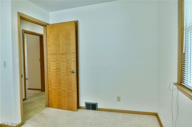 Carpeted empty room featuring visible vents and baseboards | Image 28