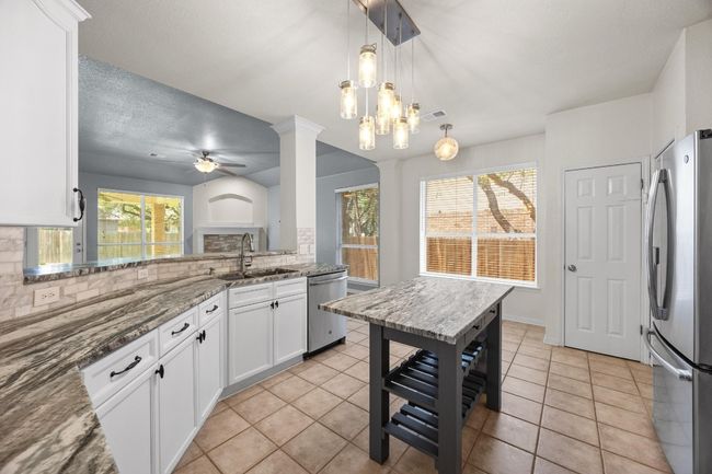 Long breakfast bar with gorgeous granite and mobile island for tons of countertop space! | Image 9