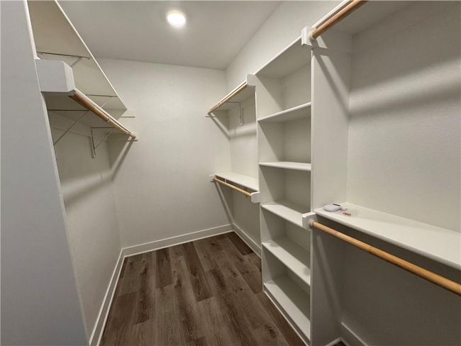 Walk in closet with dark wood-type flooring | Image 58