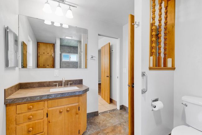 Unfurnished bedroom with a baseboard heating unit, connected bathroom, two closets, carpet, and baseboard heating | Image 13