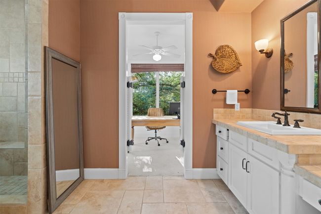 Full bath featuring vanity, baseboards, tile patterned floors, a ceiling fan, and a shower stall | Image 17