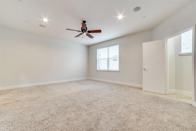 Unfurnished room featuring ceiling fan, light colored carpet, and baseboards | Image 8