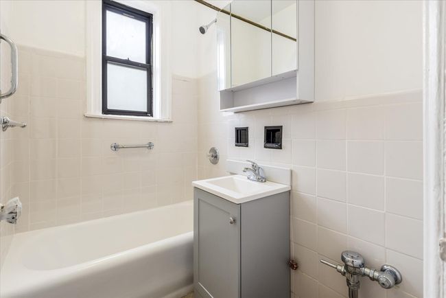 Bathroom featuring tile walls, vanity, and washtub / shower combination | Image 8