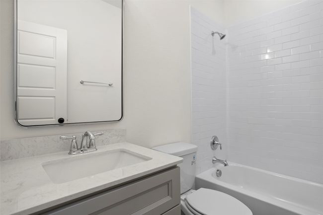 Full bathroom featuring vanity, tiled shower / bath combo, and toilet | Image 17