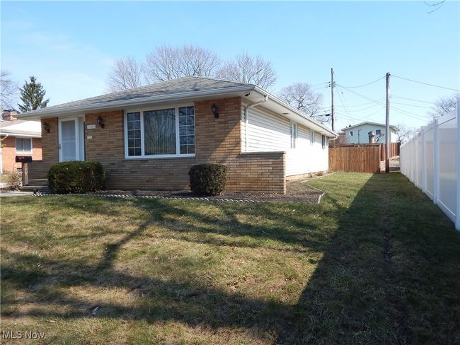 View of property exterior with fence, Landscaping, a lawn, and Brick & Vinyl siding. | Image 42